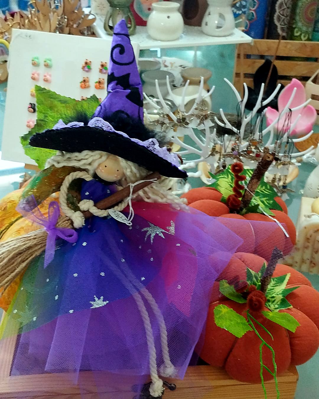 Bruja de otono con sombrero morado y calabazas decorativas