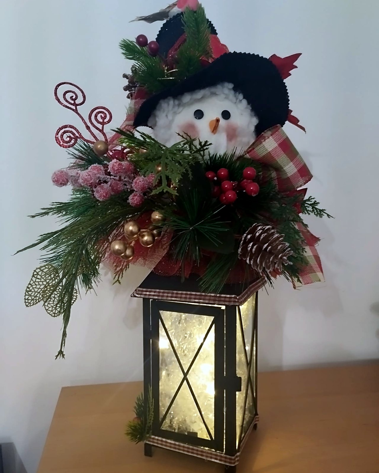 Farol navideno iluminado coronado con muneco de nieve
