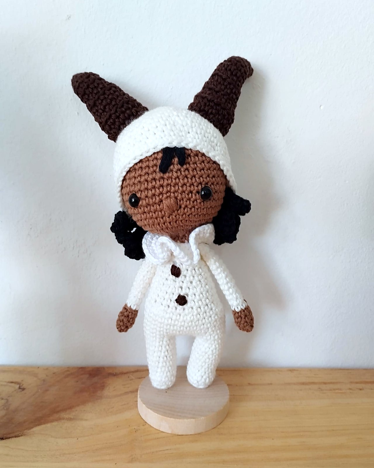 Muneca amigurumi con gorro de conejo bicolor y abrigo blanco