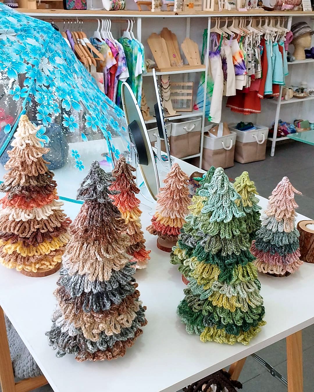 Mesa de la tienda con arboles de Navidad de lana expuestos