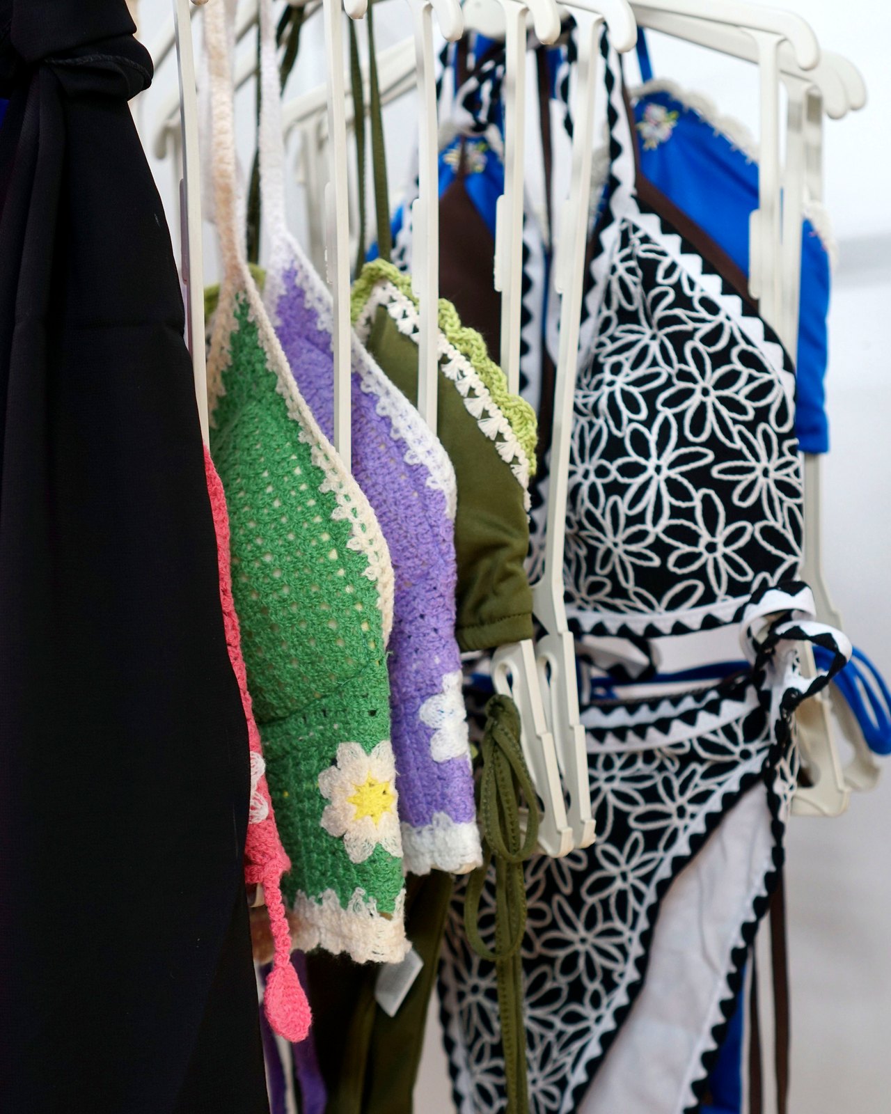 Tops y prendas de crochet colgadas en percha