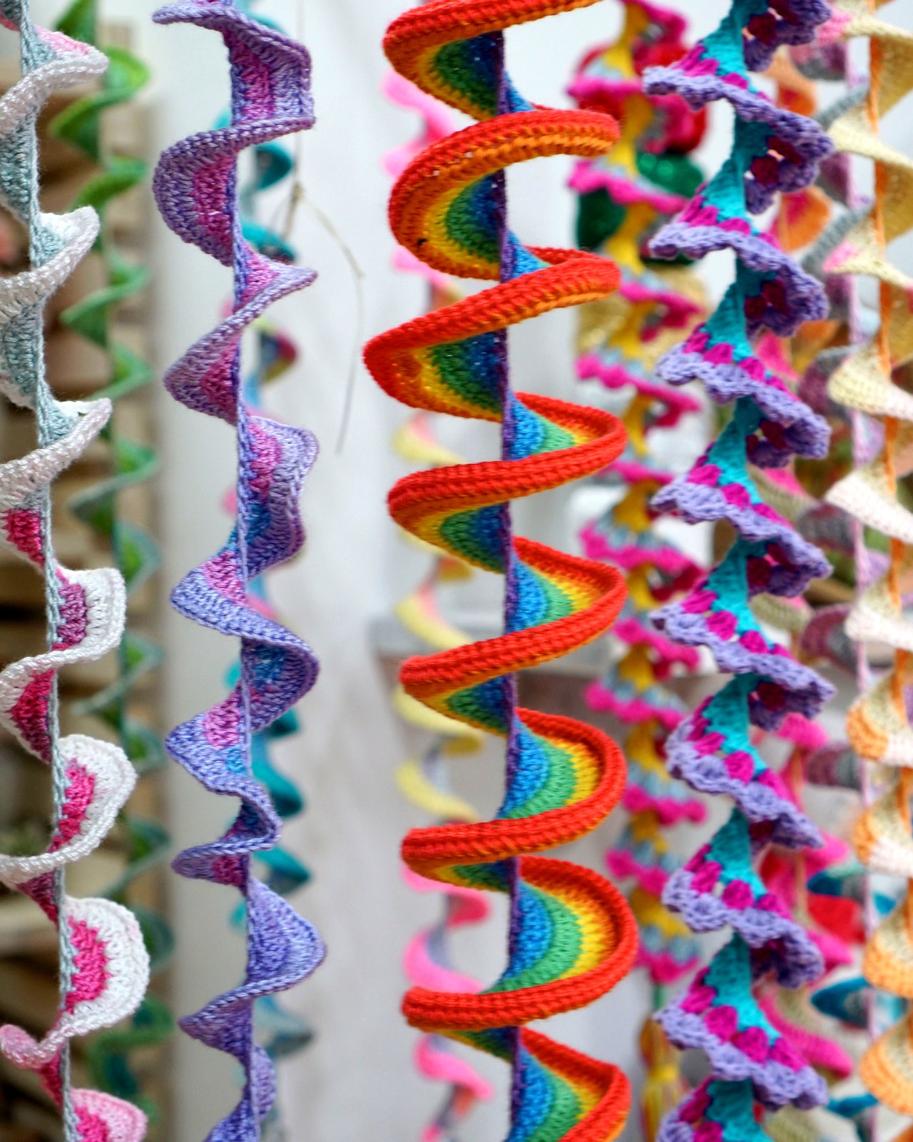 Espirales de crochet multicolor colgando en cortina