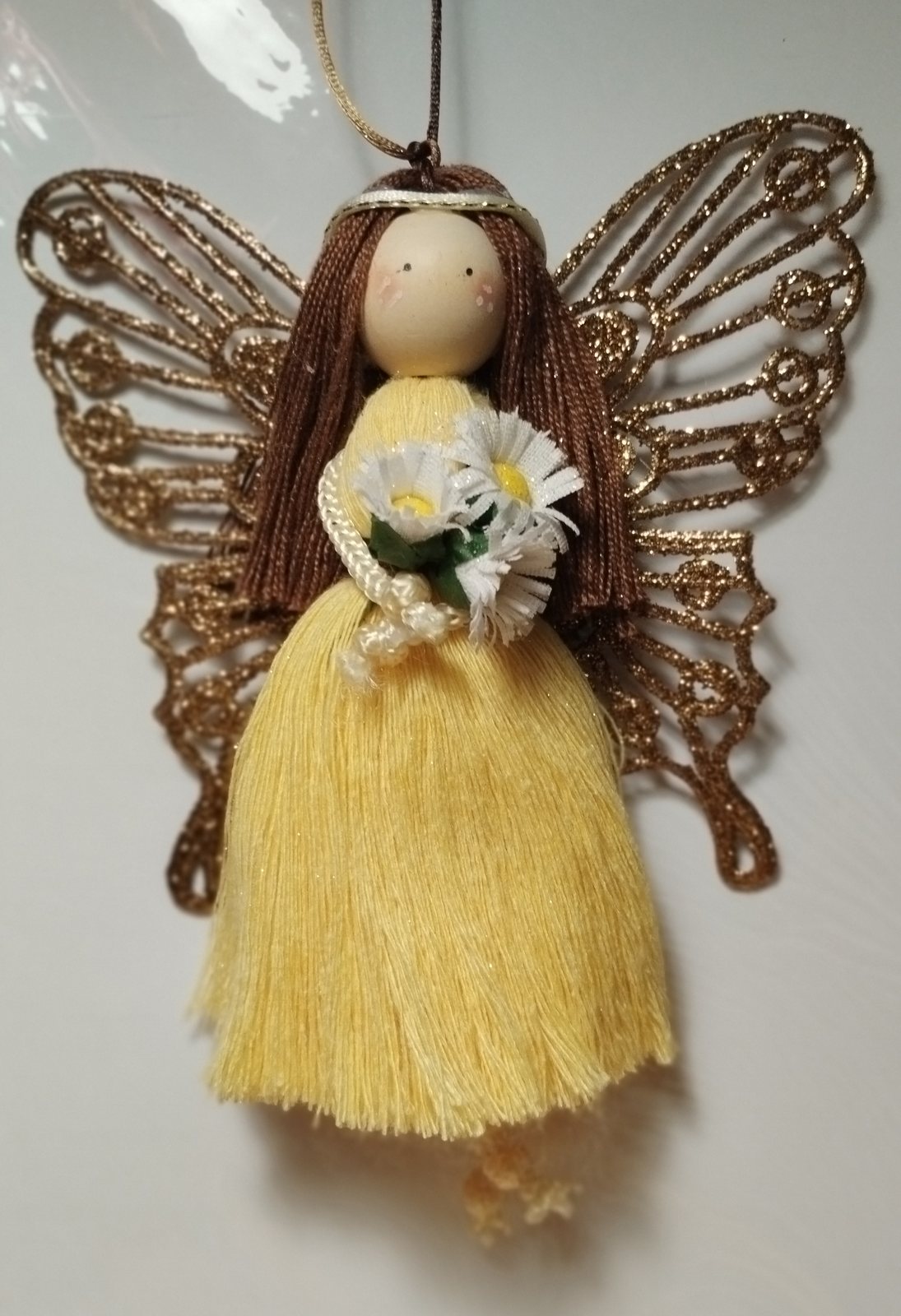 Hada mágica de macramé amarilla con alas doradas y margaritas