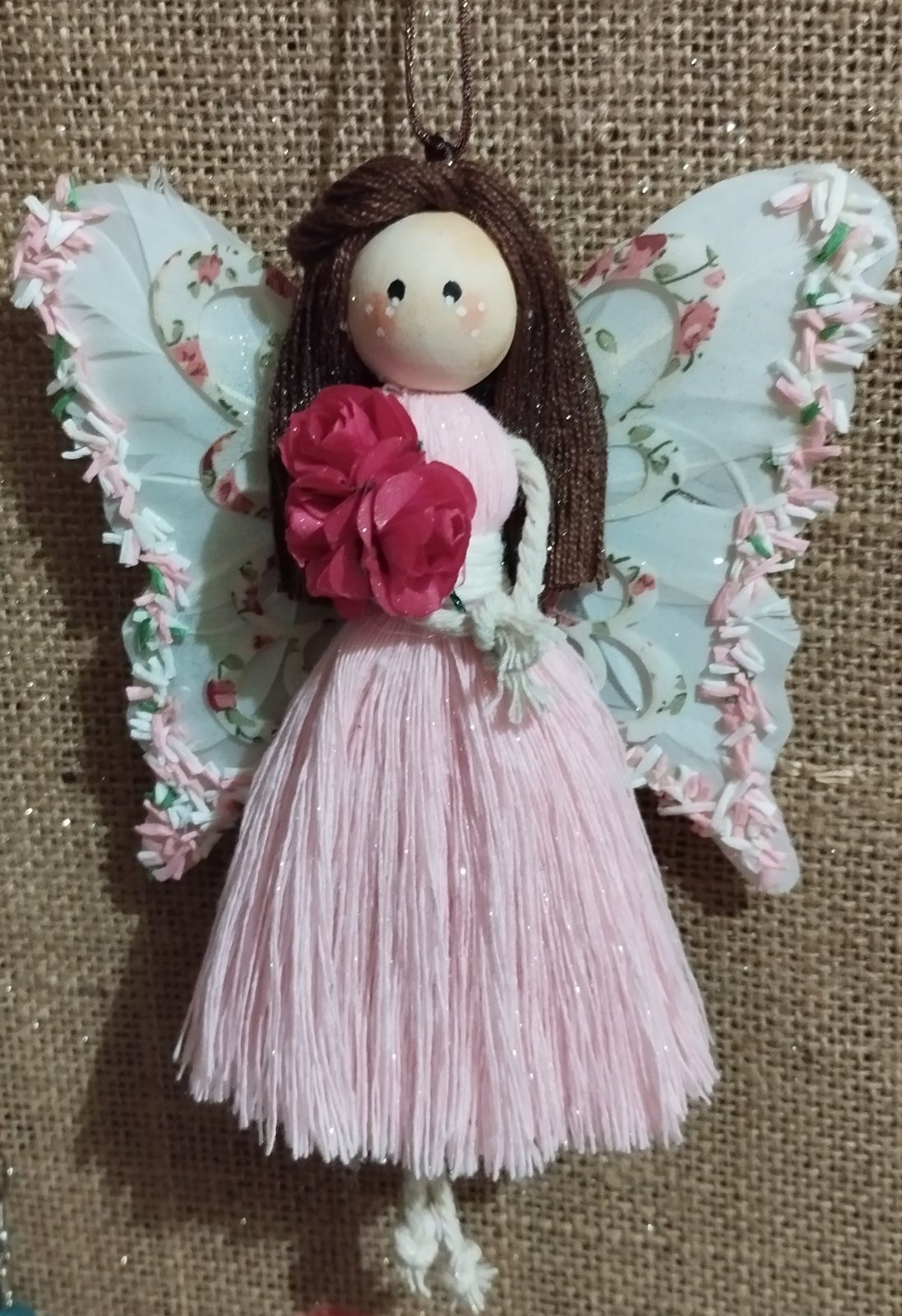 Hada mágica de macramé con falda rosa y ramo de flores